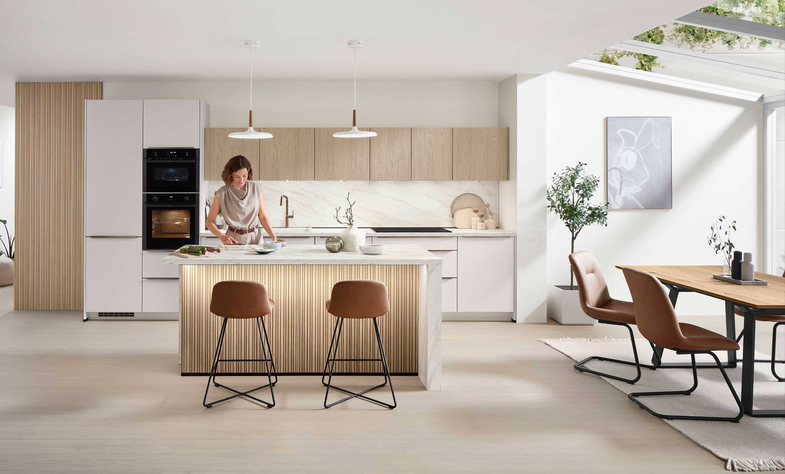 Gemütliche skandinavische Nobilia Softline 509 Küche mit zentraler Kochinsel und streiﬁger Rückwand.