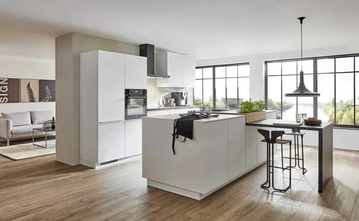 Weiße offene Wohnküche mit Kochinsel und Esstheke im skandinavischen Stil – Küchenstudio Wesel.